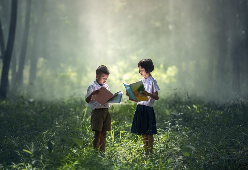 Niños leyendo un libro en un bosque que se ilumina por detrás